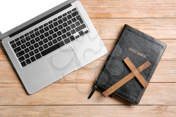Holy Bible, laptop and cross on wooden background�