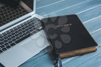 Holy Bible and laptop on table�