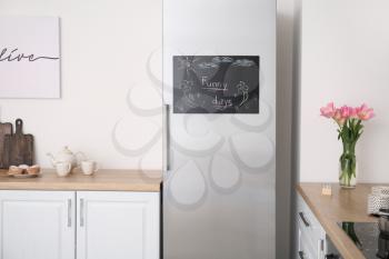 Chalkboard on door of refrigerator in kitchen�