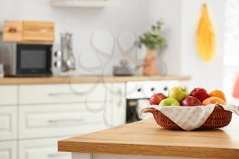 Basket with fresh fruits on table in kitchen�