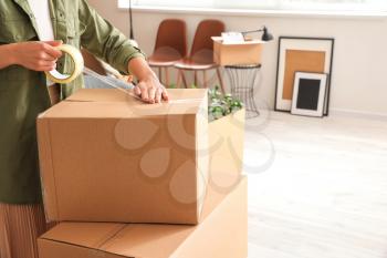 Woman packing moving box at home�