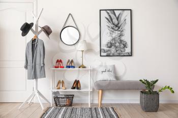 Stylish interior of modern hall with shoes on stand and bench�