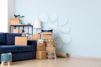 Cardboard boxes with belongings and sofa in new flat on moving day�