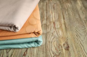 Stack of clean bed sheets on table, closeup�