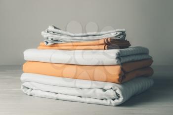 Stack of clean bed sheets on table�