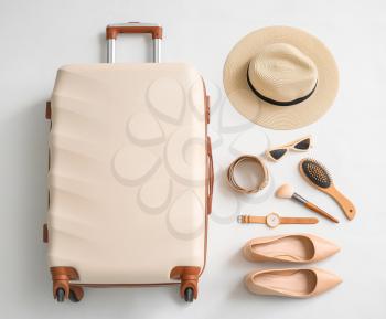 Packed suitcase and accessories on white background�