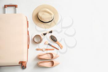 Packed suitcase and accessories on white background�