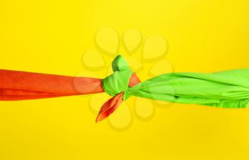 Tied handkerchiefs on color background. Unity concept�