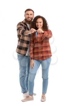 Happy young couple with car key on white background�