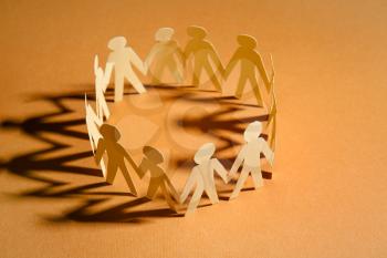 Circle made of paper human figures on table. Unity concept�