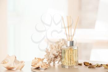 Reed diffuser and sea shells on table in room�