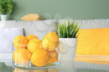 Bowl with fresh lemons on table in living room�