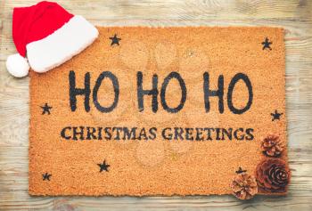 Door mat with Christmas decor on wooden background�