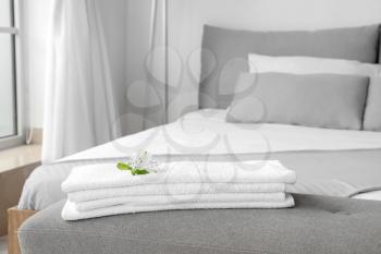 Clean towels on bedside bench in hotel room�
