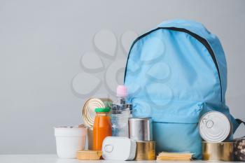 Schoolbag with different products on light background. Concept of Backpack Food Program�