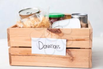 Box with donations on table against light background�