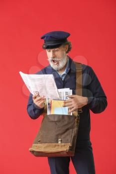 Surprised old postman on color background�