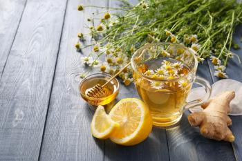 Chamomile tea with honey, lemon and ginger on table�