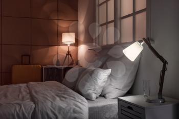 Interior of modern hotel room with glowing lamps at night�