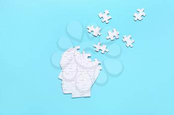 Puzzle in shape of human head on color background. Concept of dementia�
