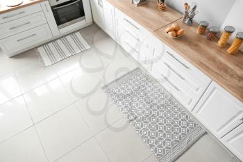 Stylish carpet on floor in modern kitchen�