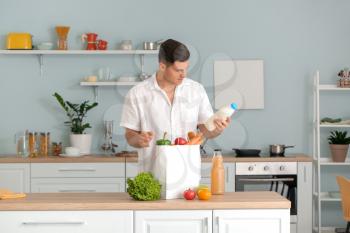 Man unpacking fresh products from market in kitchen�