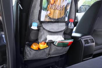Travel organizer with different things on car seat in salon�