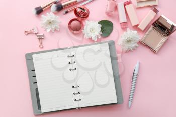 Different stationery with makeup cosmetics on color background�