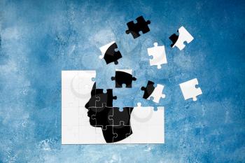 Puzzle with drawn human head on color background. Concept of dementia�