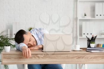 Young man falling asleep during work in office. Concept of sleep deprivation�