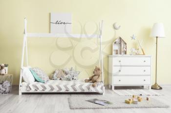 Interior of modern children's room with comfortable bed and chest of drawers�
