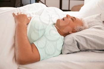 Mature man snoring while sleeping in bed. Apnea problem�