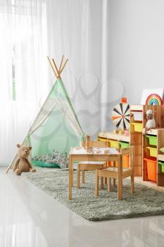 Interior of modern children's room with play tent and toys�