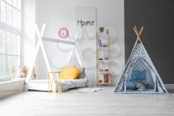 Interior of modern children's room with play tent and bed�