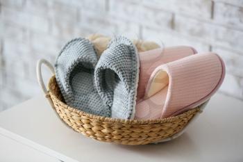 Basket with soft slippers on table�