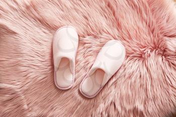 Pair of soft slippers on fluffy rug�
