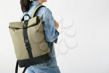 Young woman with backpack on white background�