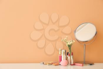 Set of decorative cosmetics and mirror on dressing table 