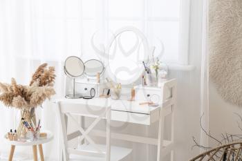 Set of decorative cosmetics on dressing table in room�