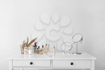 Set of decorative cosmetics and mirrors on dressing table�