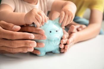 Family with piggy bank at table�
