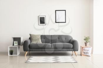 Comfortable sofa near white wall in room�