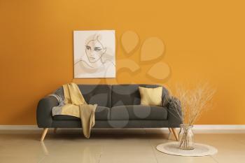 Comfortable sofa near color wall in room�