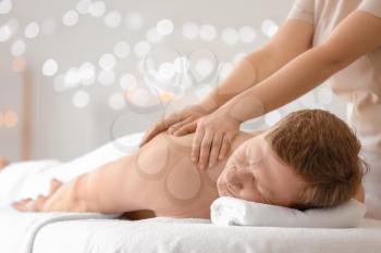 Handsome man receiving massage in spa salon�