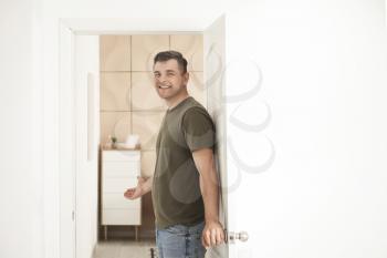 Happy man inviting guest at his new home�