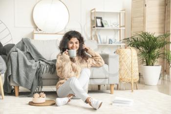 Beautiful young woman drinking hot tea at home�