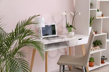 Stylish interior of room with green houseplants and workplace�