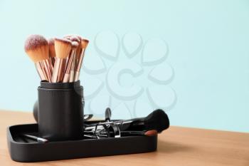 Set of makeup brushes with items on table�