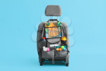 Travel organizer with different things on car seat against color background�