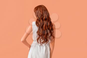 Beautiful young redhead woman on color background, back view�